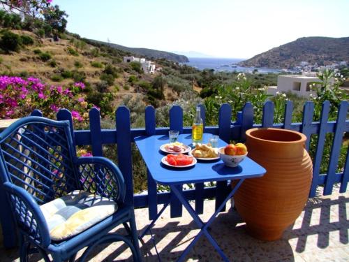 a blue table with a plate of food on it at Villa Costa Studios in Vathi, Sifnos