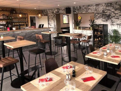 a restaurant with wooden tables and chairs and a bar at beaujour & bonsoir Brasserie-Hotel in Villy-le-Pelloux