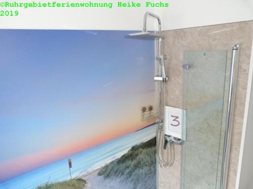5x Fuchs-Dobry Balkon-Apartments 40qm-65qm في أوبرهاوزن: كشك للاستحمام مع لوحة على الشاطئ