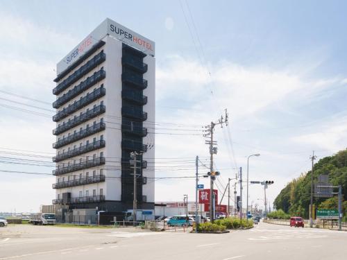 a building with a sign on the top of it at Super Hotel Anan Tomioka in Anan