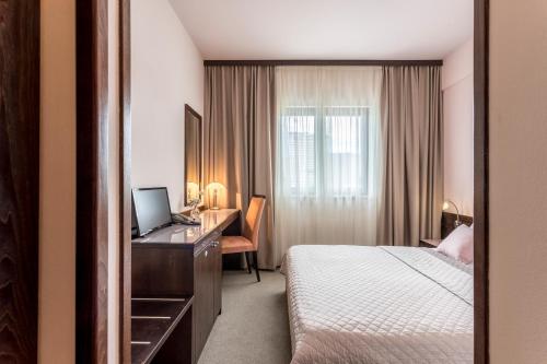 Habitación de hotel con cama y escritorio con ordenador en Hotel As en Split