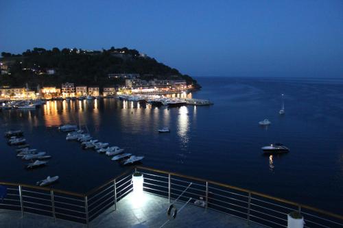 a harbor with boats in the water at night at Hotel Plaza in Porto Azzurro