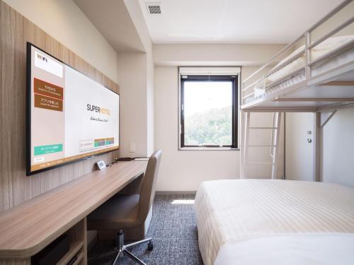 a hotel room with a desk and a projection screen at Super Hotel Anan Tomioka in Anan
