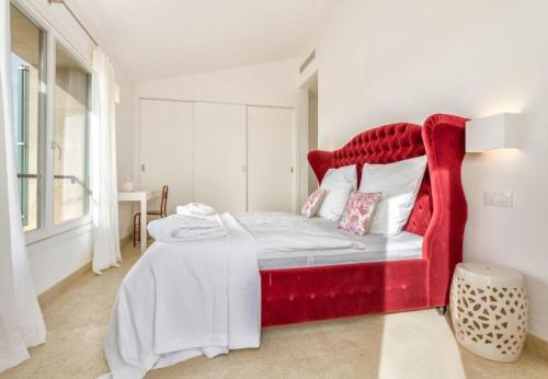 a bed with a red headboard in a room at Finca El Idilio in Ses Salines