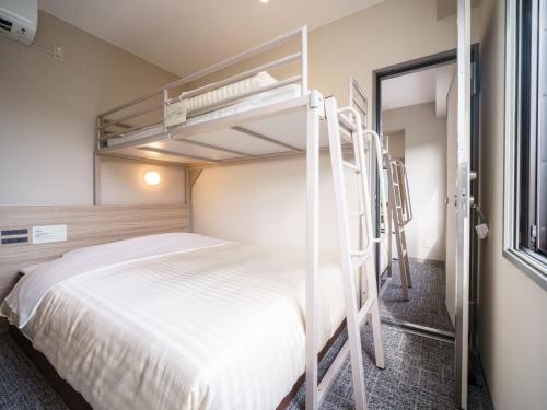 a bedroom with two bunk beds and a window at Super Hotel Anan Tomioka in Anan