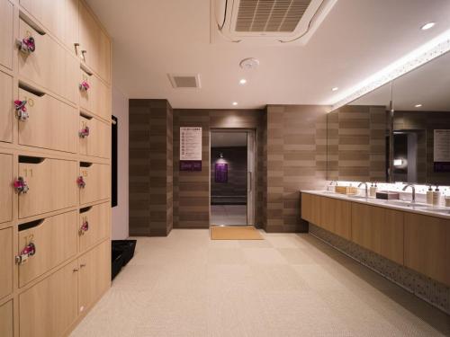 a large bathroom with two sinks and a mirror at Super Hotel Anan Tomioka in Anan