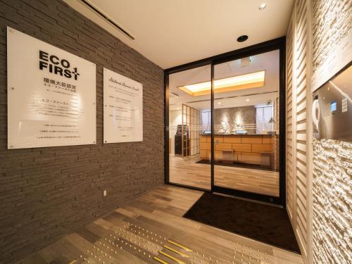 a store front with a window and a brick wall at Super Hotel Anan Tomioka in Anan