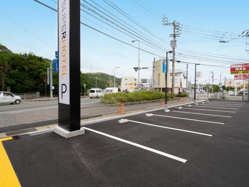 an empty parking lot with a sign on it at Super Hotel Anan Tomioka in Anan