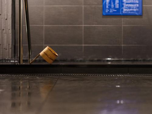 a cup sitting on the floor of a bathroom at Super Hotel Anan Tomioka in Anan
