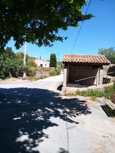 a small building with a roof on the side of a road at Chambre du Charron in Azillanet