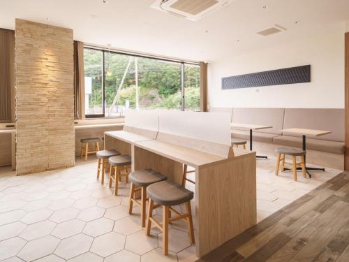 a room with a large table and stools at Super Hotel Anan Tomioka in Anan