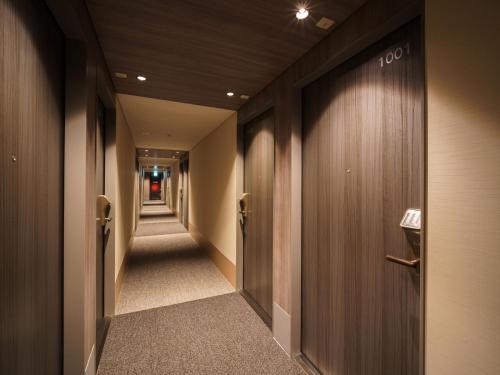 a hallway with wooden walls and a long corridor at Super Hotel Anan Tomioka in Anan