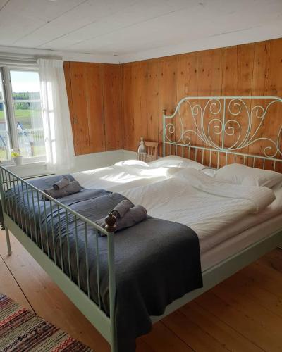 a large bed with a metal frame in a bedroom at Hofra Bed & Breakfast in Delsbo