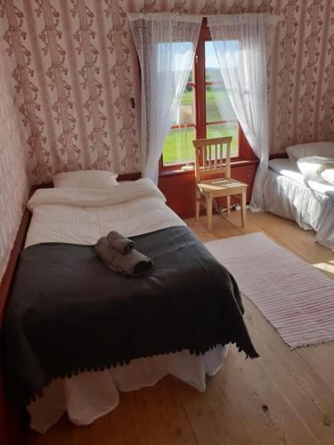 a bedroom with a bed with a teddy bear on it at Hofra Bed & Breakfast in Delsbo