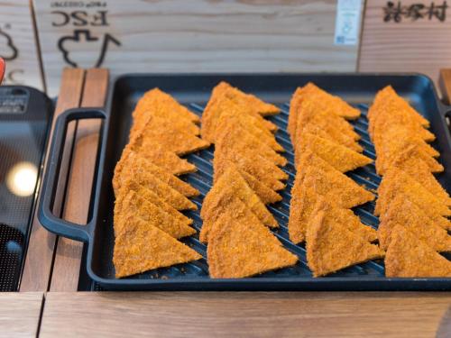 a tray of fried food on a grill at Super Hotel Anan Tomioka in Anan