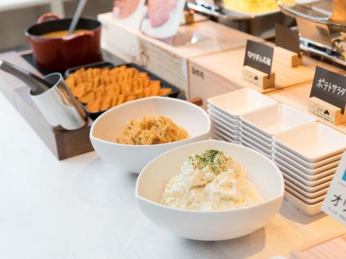two bowls of food on a counter with snacks at Super Hotel Anan Tomioka in Anan