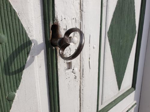 uma maçaneta de metal numa porta com uma janela em Hofra Bed & Breakfast em Delsbo