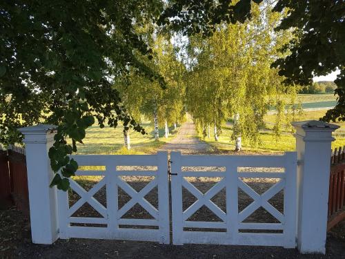 a white gate in front of a driveway at Hofra Bed & Breakfast in Delsbo