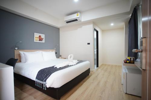 a bedroom with a large white bed in a room at Tisa Hotel Udonthani in Udon Thani