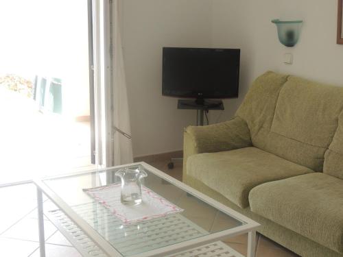 a living room with a couch and a glass coffee table at Apartamentos Parque Mar in Cala d´Or
