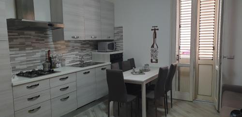 a kitchen with a table with chairs and a counter top at Casa di Mena in Alghero