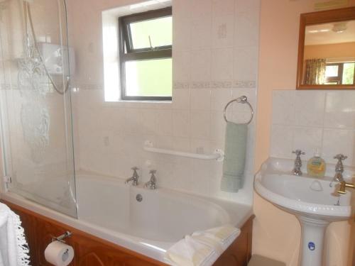 ein Bad mit einer Badewanne, einem Waschbecken und einer Dusche in der Unterkunft Glen House Room Only Accommodation in Youghal