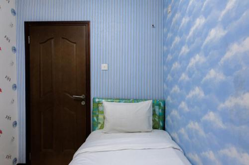 a bed with a pillow next to a door at 2BR Apartment at 18th Floor Great Western By Travelio in Tangerang