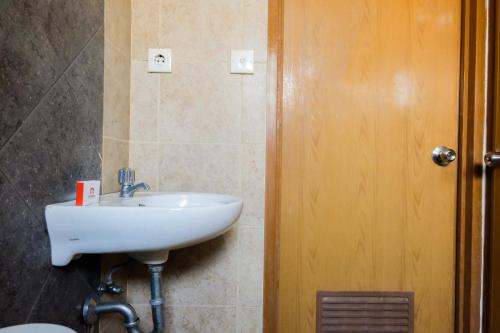 a bathroom with a white sink next to a door at 2BR Apartment at 18th Floor Great Western By Travelio in Tangerang