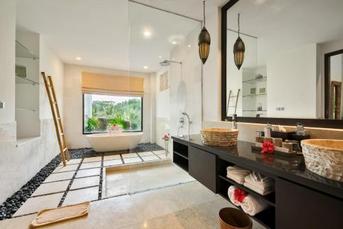 a bathroom with a tub and a large mirror at Villa Kembang Bali Ubud in Ubud