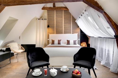 une chambre avec un lit, deux chaises et une table dans l'établissement Maison des Ducs, à Dijon