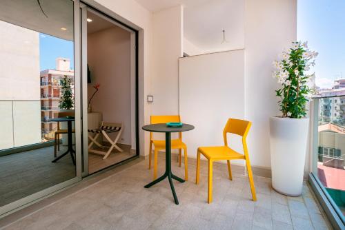a small table and chairs in a room with a balcony at Manzoni Elements in Milazzo