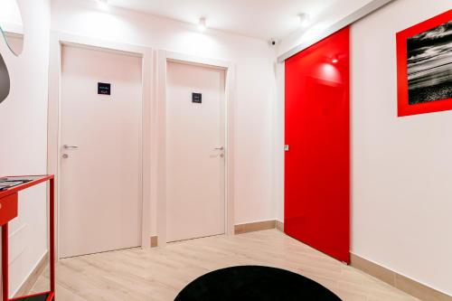 a room with two doors and a red wall at Manzoni Elements in Milazzo
