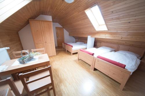 a attic room with two beds and a desk at Tourist Farm Pr'Dovar in Cerklje na Gorenjskem