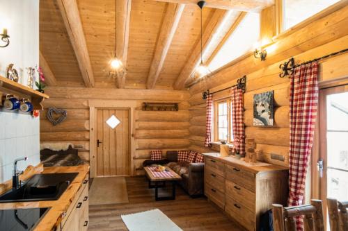 eine Blockhausküche mit Holzwänden und -decken in der Unterkunft Chalet Ellerbeck in Langdorf