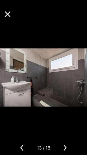 a bathroom with a sink and a toilet and a window at Villa Barchelona in Kallirákhi