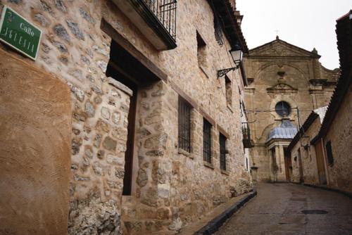 an alley in an old stone building with a street sign at Apartamentos Los Tremedales in Orihuela del Tremedal