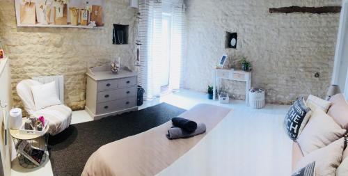 ein Schlafzimmer mit einem Bett, einem Sofa und einem Stuhl in der Unterkunft Bienvenue à la maison in Sainte-Soulle