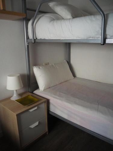 une chambre avec deux lits superposés et une table de chevet dans l'établissement APARTAMENTO MAR I CEL, à Blanes