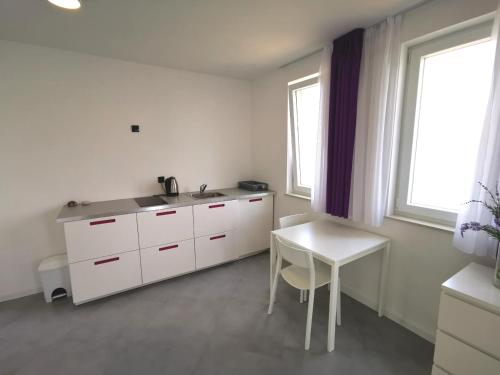 a white kitchen with a sink and a table at Hrvoje in Pag