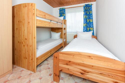 a bedroom with two bunk beds and a window at Haus Hafeneck mit Frühstücksoption in Bensersiel