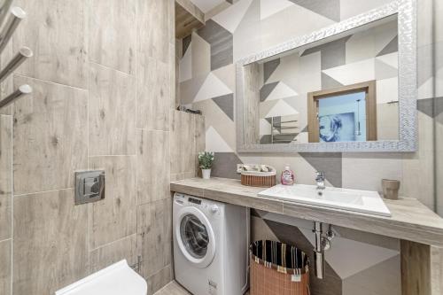 a bathroom with a washing machine and a sink at Arcadia Sweet LOFT Style! in Odesa