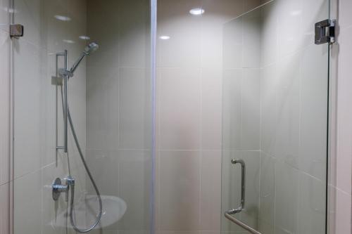 a shower stall with a glass door and a glass shower constructor at 3BR Apartment with Pool View at M-Town Signature By Travelio in Tangerang
