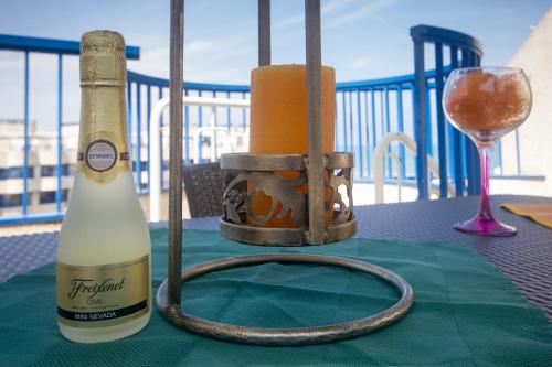 una botella de vino y una copa en una mesa en Patacona Resort Apartments Primera Linea, en Valencia