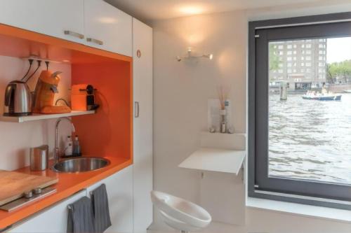 a kitchen with a sink and a window with a view at Houseboat Ark van Amstel in Amsterdam
