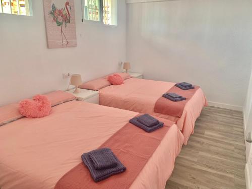 3 Betten in einem Zimmer mit rosa Bettwäsche in der Unterkunft Pink Beach Benidorm in Benidorm