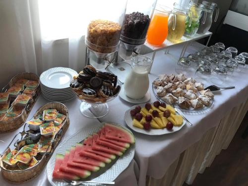 Una mesa con un buffet de comida y bebidas. en Leszczynowy Dworek, en Gdansk