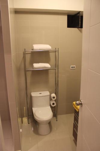 a bathroom with a white toilet and some towels at Apartamento dúplex exclusivo y céntrico in Lima