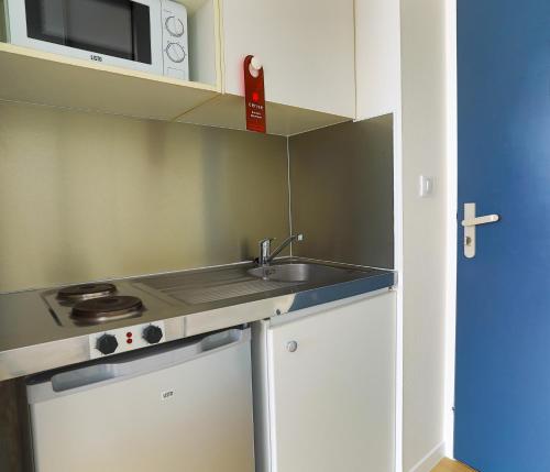 uma pequena cozinha com um lavatório e um micro-ondas em Cerise Nantes La Beaujoire em Nantes