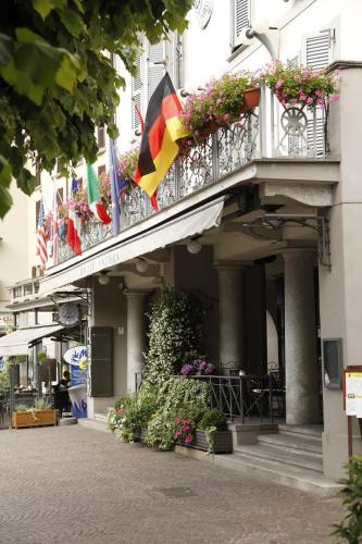 a building with a balcony with flags on it at Hotel Ancora in Verbania