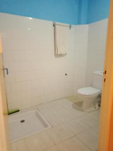 a white bathroom with a toilet and a tub at maison de vacance in Tafraoute